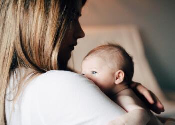 woman in white shirt carrying baby