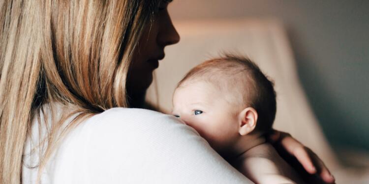 woman in white shirt carrying baby