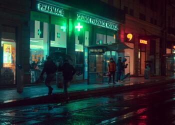 man and woman walking on sidewalk during night time