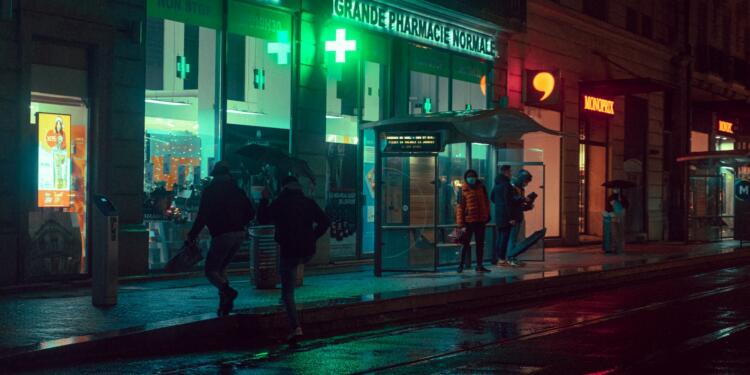 man and woman walking on sidewalk during night time