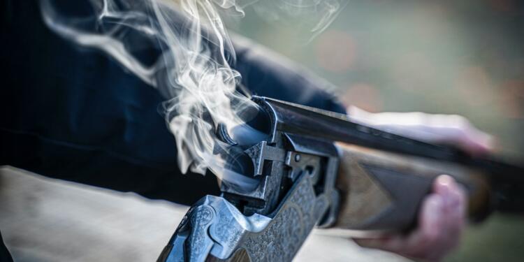 black semi automatic pistol with white smoke