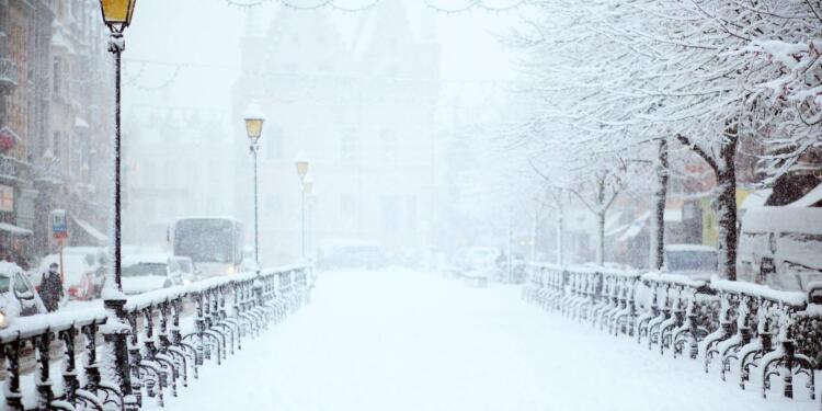 road covered by snow near vehicle traveling at daytime