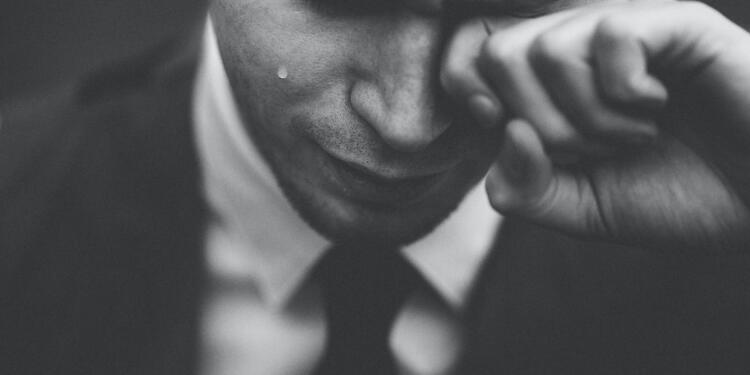 man wiping his tears