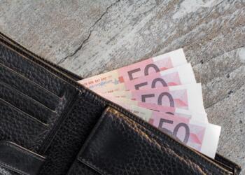 a wallet with a bunch of money sticking out of it