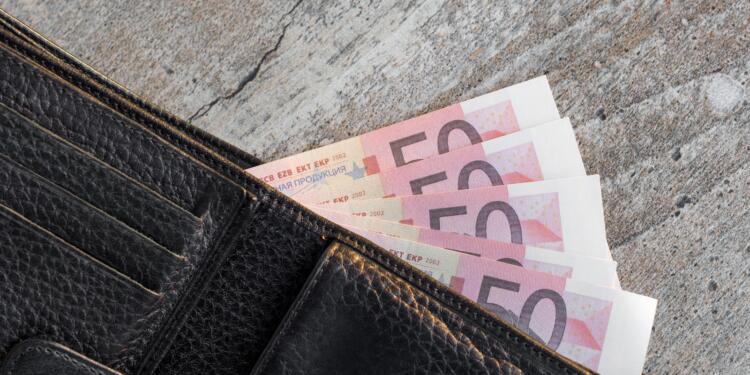 a wallet with a bunch of money sticking out of it