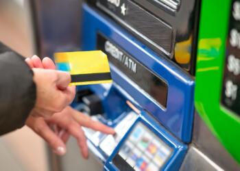 a person using a credit card to pay for a machine