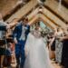 bride and groom standing beside brown wooden wall