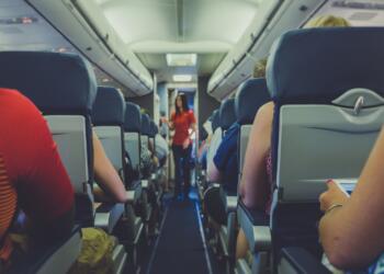 flight attendant standing between passenger seat