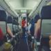 flight attendant standing between passenger seat