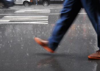 man wearing blue pants walking on street