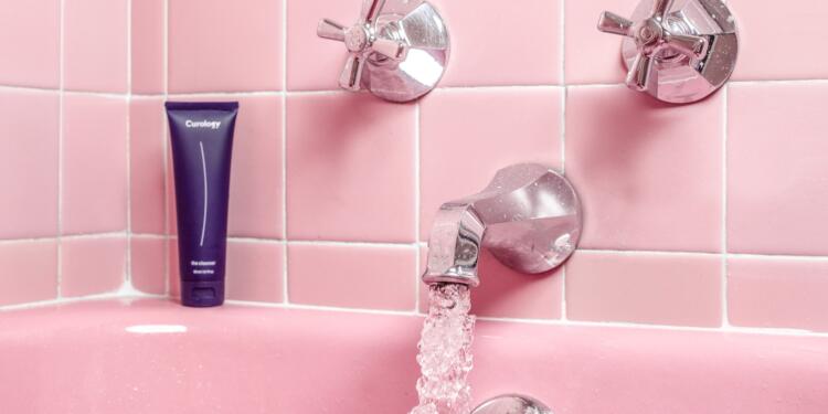 a pink bathtub with a faucet and soap dispenser