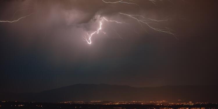 lightning strike over the city during night time