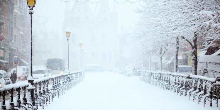 road covered by snow near vehicle traveling at daytime