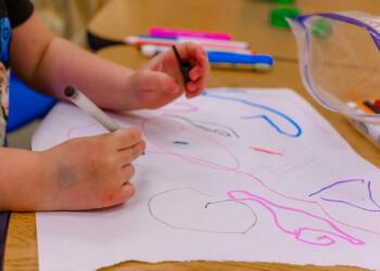 a child is drawing on a piece of paper