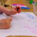 a child is drawing on a piece of paper