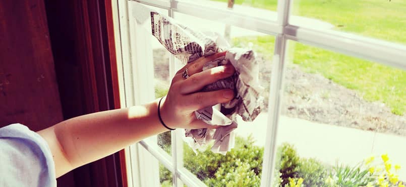 cleaning a window with newspaper