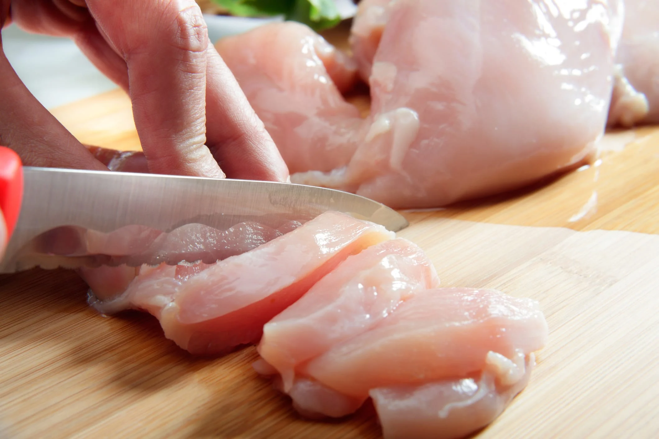 silcing raw chicken photo